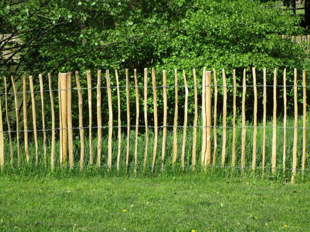 Handgespaltener Hartholz-Rollzaun in Wiese